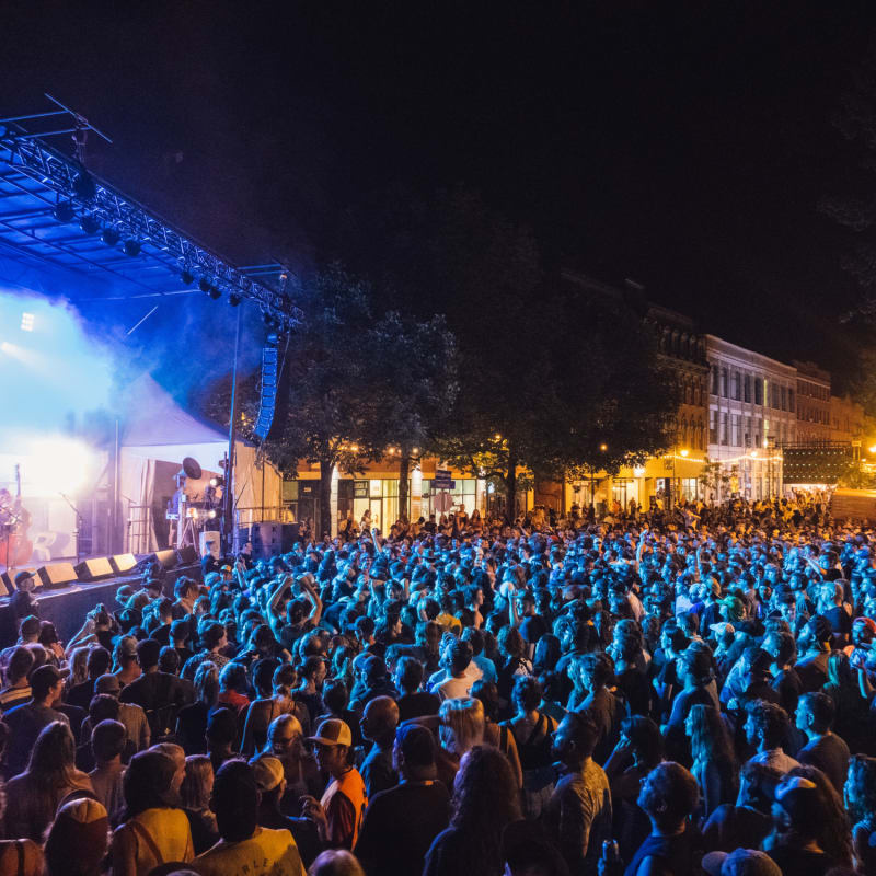 Foule en soirée devant une scène extérieure au Festival Sherblues.